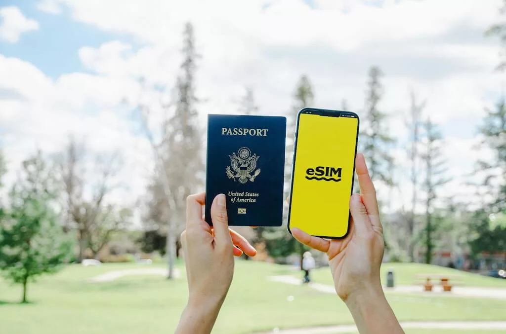 ODM-Phone-Usage-in-Morocco-Passport A person ready for phone usage in Morocco, holding a passport in their left hand and a smart phone saying "eSIM" in the right hand.