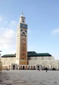 beige, green, blue stone mosque against vibrant blue sky