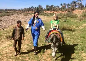 tourist riding a donkey with two locals