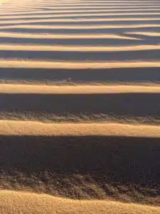 An aerial view of the Saharan dunes with wavy patterns that you will witness on the custom and shared tours by Open Doors Morocco