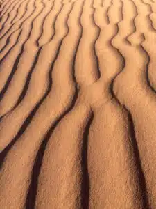 An aerial view of the Saharan dunes with wavy patterns that you will witness on the custom and shared tours by Open Doors Morocco