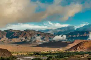 the High Atlas Mountains surrounded by a few clouds, seen from a valley