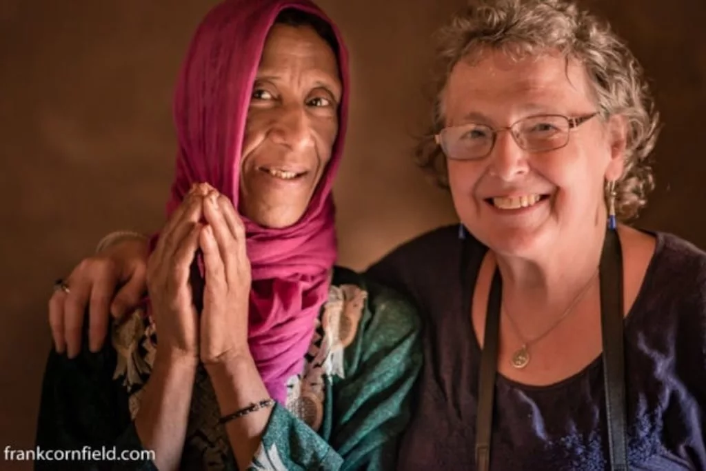 a female traveler hugging a local Moroccan woman while posing for a picture together
