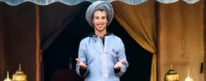 a local tour operator in Morocco standing in front of a beduin camp and smiling while receiving his guests