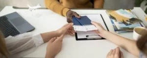 a person handing out two passports together with a travel protection for Morocco to his clients