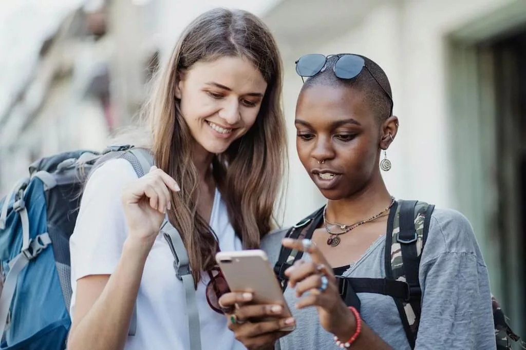 Two female travelers testing phone usage in Morocco by trying to connect to the local net after purchasing a Moroccan SIM card.