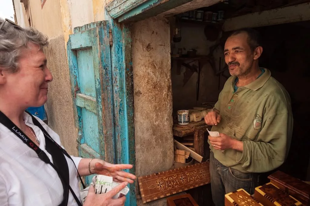 A tourist in the act of bargaining with a Moroccan artisan at the doorstep of his shop at the markets in Morocco.