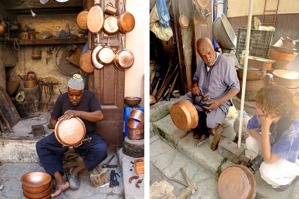 At the markets in Morocco: a local artisan working on his handmade pans and pots while talking to a tourist.