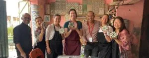A group of guests posing for a picture with their artworks after attending a tile workshop with Hassan, one of the best cultural experiences in Morocco.