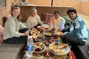 Guests sharing dinner in a typical Moroccan home - the perfect cultural experience in Morocco and the best way to connect with the locals.