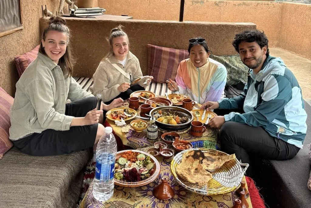 Guests sharing dinner in a typical Moroccan home - the perfect cultural experience in Morocco and the best way to connect with the locals.
