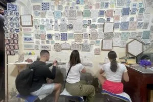 A family of travelers learning how to carve in plaster during a workshop in a local art studio.