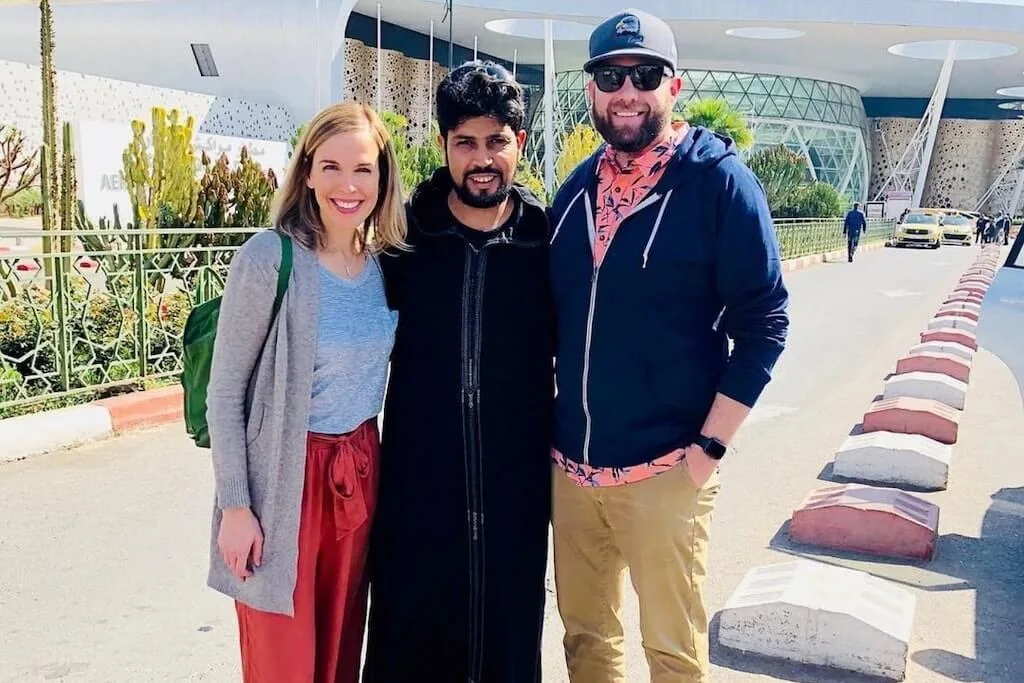 A couple taking a picture with their local guide from Open Doors Morocco after a successful Morocco itinerary full of romantic getaways across the country.