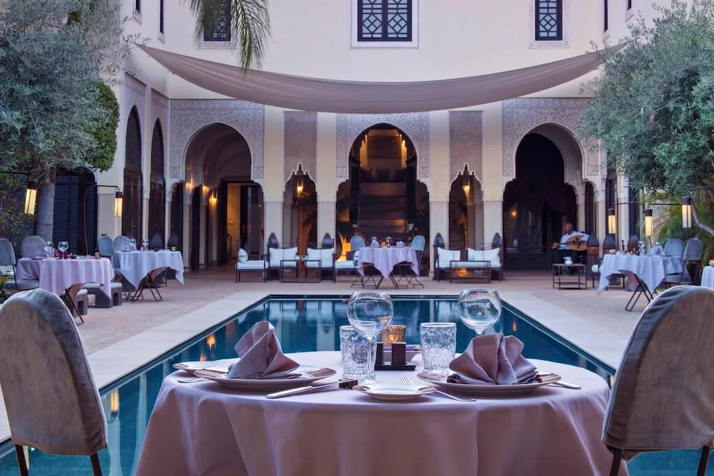 Inside the courtyard in Villa des Oranges, a luxury riad with a table set for a romantic dinner for two.
