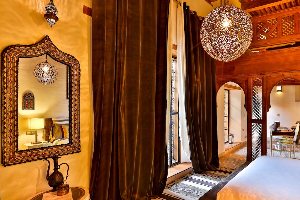 a prime example of an intricate interior design of a traditional Moroccan riad – the picture shows carved wooden ornaments and decorations inside a private suite