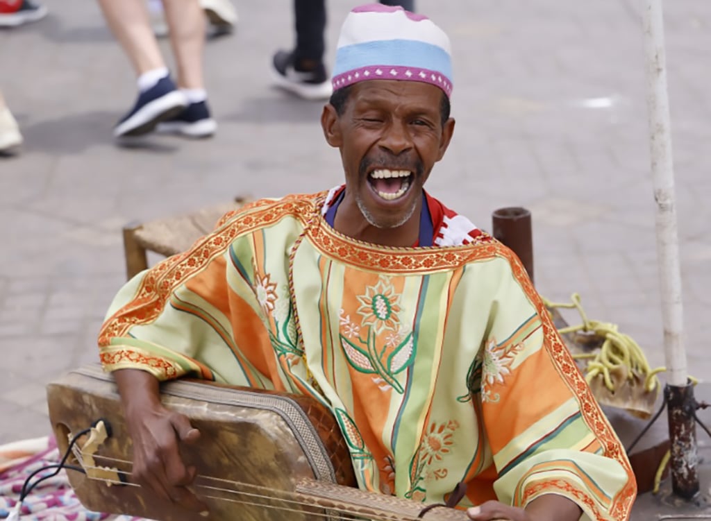 A street musician playing an instrument during the Gnawa Music Festival in Essaouira