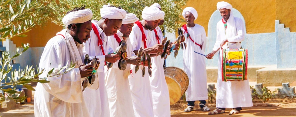 Moroccan men in traditional clothing playing instruments and dancing to a folk music during one of moroccan festivals