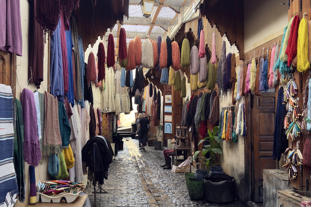 a corridor full of colorful cloths hanging from the ceiling in the dyers district of Souk Sebbaghine