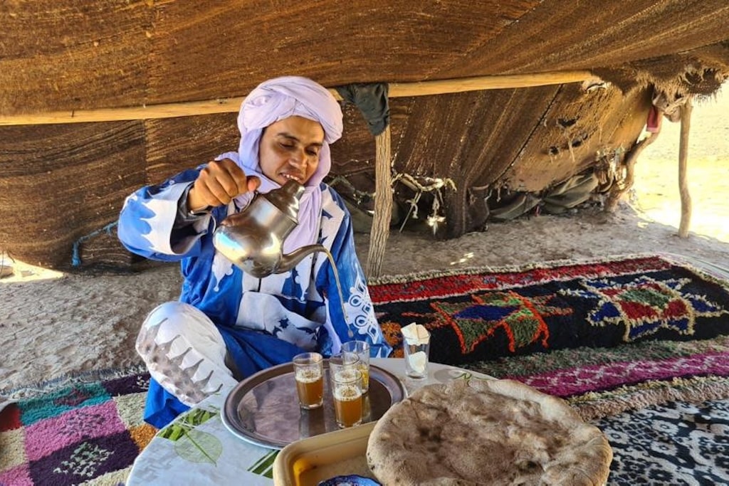 A Moroccan man pouring the traditional Moroccan mint tea for his guests – a sign of the typical hospitality in Morocco