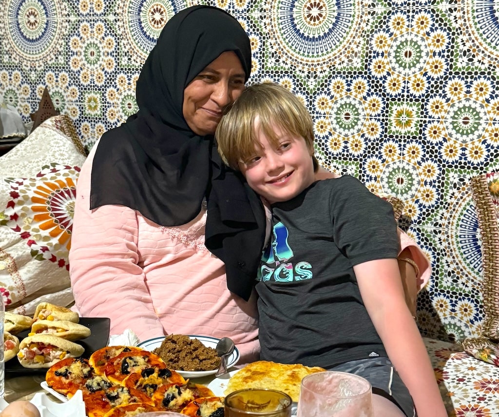 a little boy guest being hugged by a local Moroccan woman while visiting Morocco in Ramadan