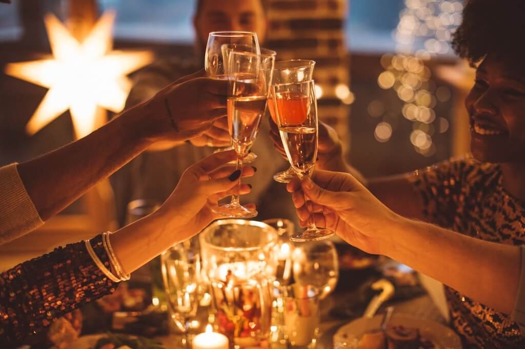 A group of friends raising their champagne glasses for a toast during the New Year celebration in Morocco.