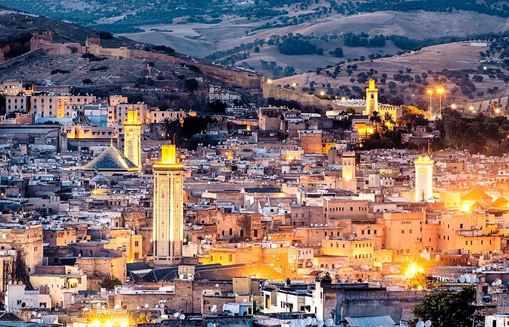 The city of Fes in Morocco seen from above at night, with the historical medina dominating the view.